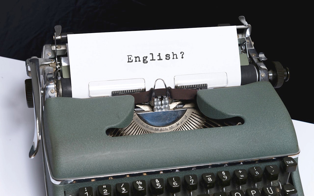 vintage typewriter holding paper showing the word English?