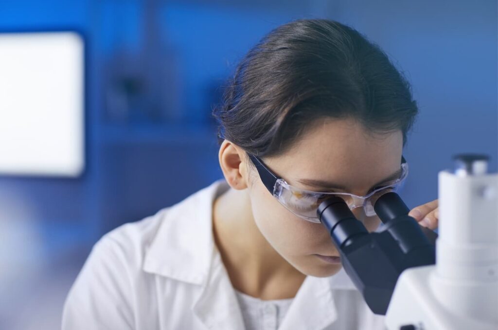 lab tech using microscope